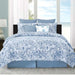 Blue and white floral patterned comforter set on a bed with a window view.
